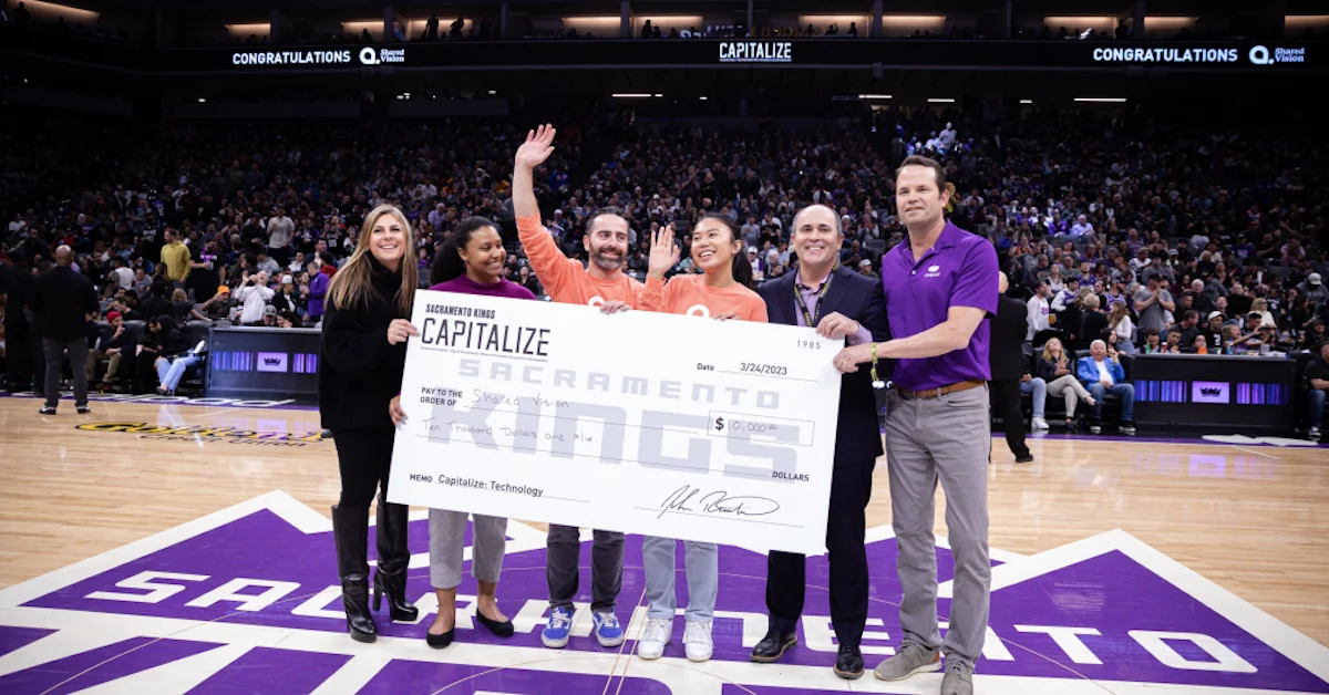 Photo announcing Shared Vision as the Sacramento Kings 2023 Capitalize Technology Winner for Affiliate Marketing SaaS with check given at halftime on court