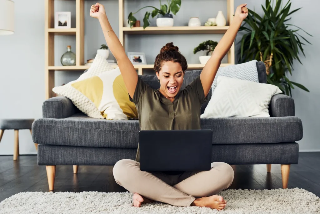 Woman celebrating with laptop because she joined Shared Vision.