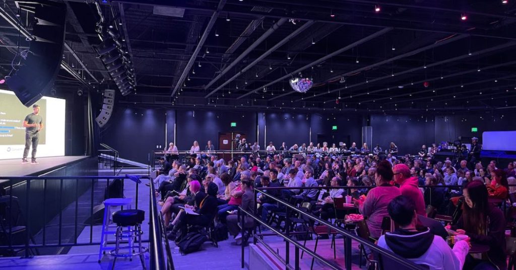 Photo of conference speaker and audience.